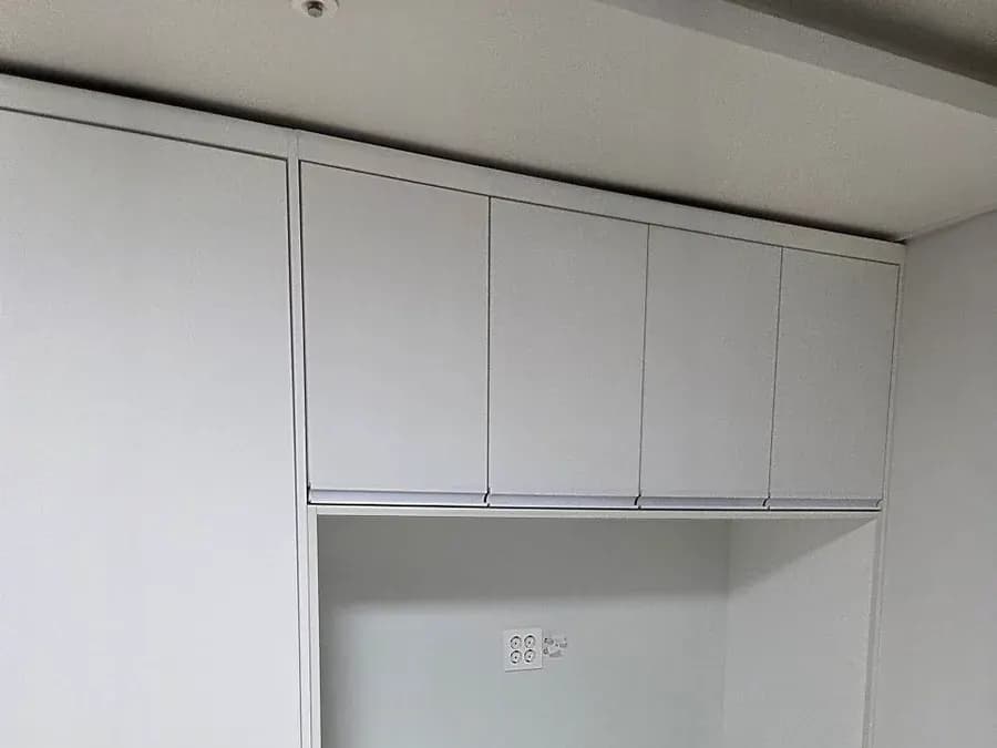 가운데 한 칸을 열어 둔 흰색 수납장